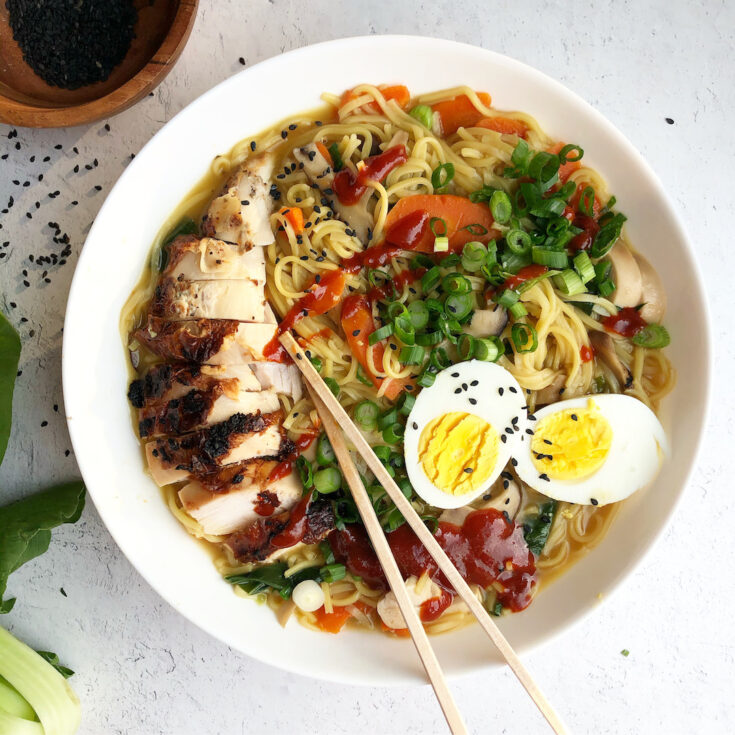 Ramen in a bowl topped with egg and chicken