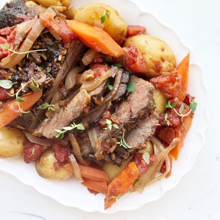 Crockpot roast with vegetables on a white platter