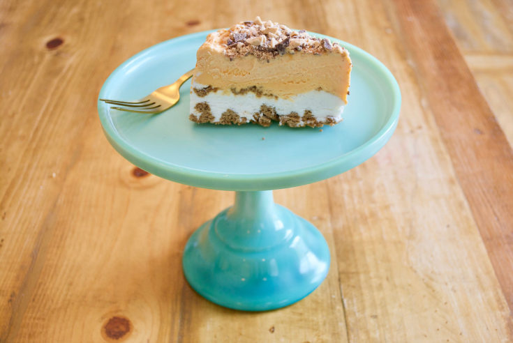 pumpkin gingersnap ice cream cake on a teal cake stand with a fork.