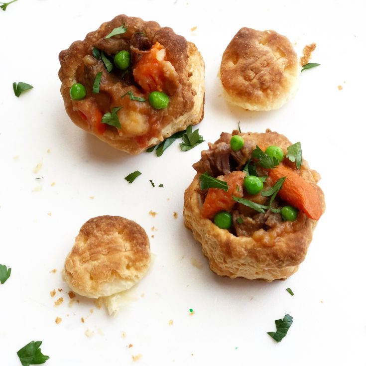 Beef stew in puff pastry cups on a white background