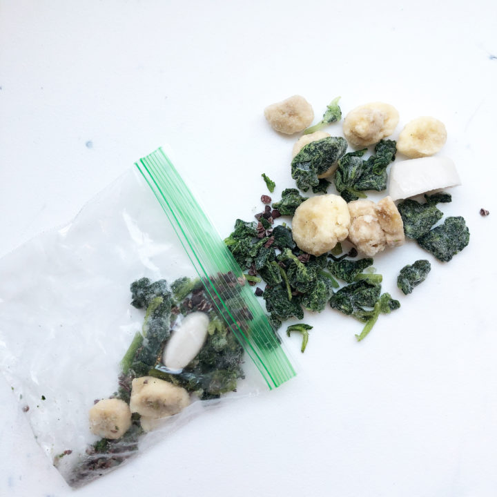 frozen spinach, banana, cashew ice cubes in a sandwich bag