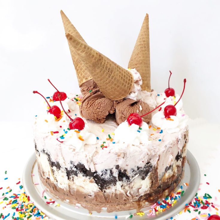 ice cream cake with cherries on top and ice cream cones