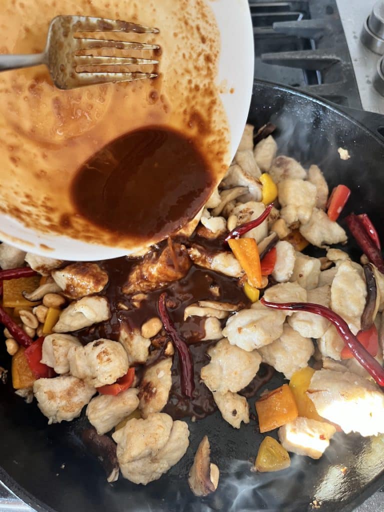 Adding the sauce to the kung pao chicken